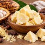 Manteca de cacao pura en trozos junto a frutos y semillas de cacao
