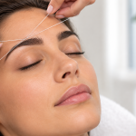 Mujer recibiendo depilación con hilo en las cejas