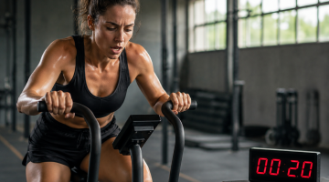 Mujer realizando entrenamiento HIIT de alta intensidad en bicicleta