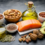 Alimentos ricos en grasas saludables como salmón, aguacate, aceite de oliva, frutos secos y semillas