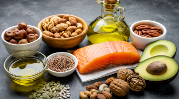 Alimentos ricos en grasas saludables como salmón, aguacate, aceite de oliva, frutos secos y semillas
