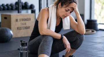 Mujer con fatiga después del ejercicio por posible sobreentrenamiento